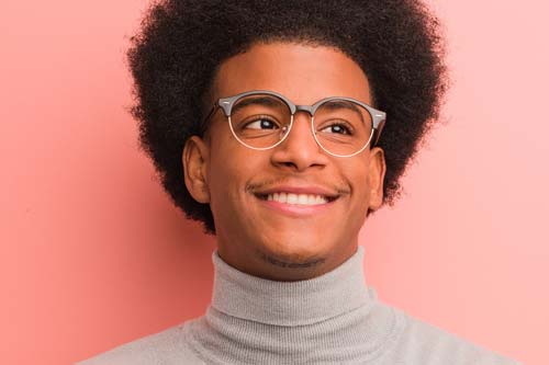 specialist services man in glasses smiling pink background