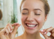 woman closing her eyes about to floss after learning how to prevent tooth decay with natural tooth decay prevention