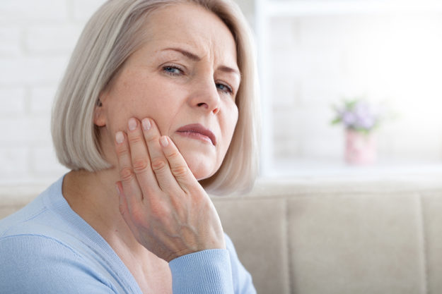 common dental problems (2) woman holding her jaw from painful Common Dental Problems