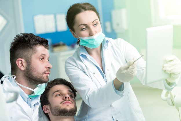 causes of receding gums dentist explaining the Causes of Receding Gums