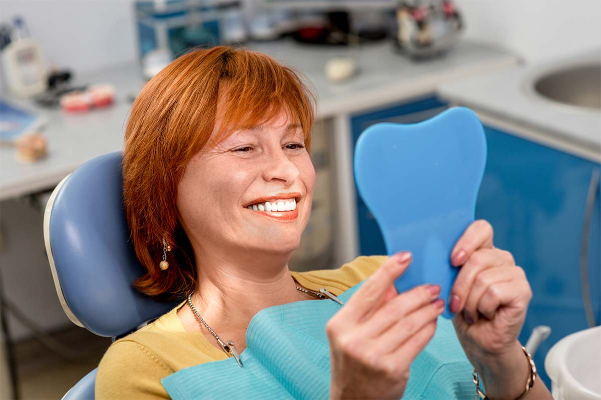 denchures woman smiling at her dentures