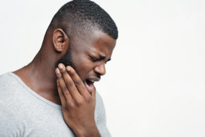 man struggles with the effects of impacted teeth 