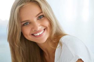 a woman smiles after her teeth whitening procedure