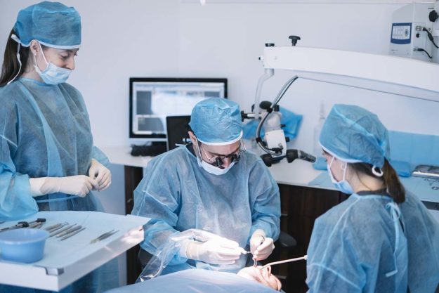 4 Common Types of Oral Surgeries (2) dentists performing oral surgeries
